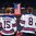 BUFFALO, NEW YORK - DECEMBER 26: USA's Scott Perunovich #15 and Adam Fox #8 stand alongside their teammates for the national anthem following their victory against Denmark during the preliminary round of the 2018 IIHF World Junior Championship. (Photo by Andrea Cardin/HHOF-IIHF Images)